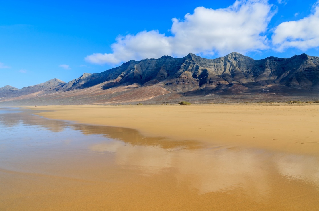 'Reflection of mountains in wet sand on Cofete beach in secluded part of Fuerteventura, Canary Islands, Spain' - Kanaren